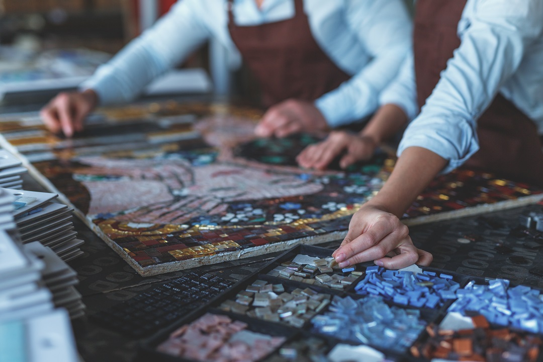 Human hands with mosaic in workshop